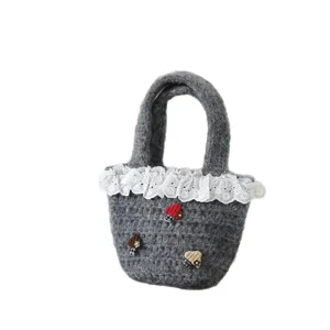 Süße graue Strickhandtasche mit weißer Spitzenborte und Mini-Pilz-Dekoration für Damen.