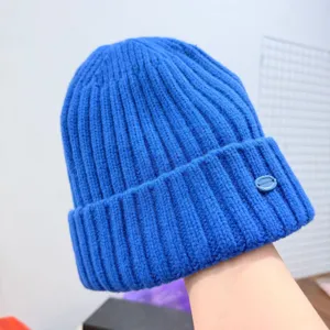 Détail du bonnet en tricot bleu montrant une texture de laine douce et un large revers.