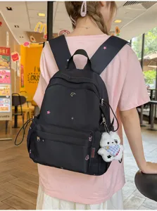 Sac à dos noir avec étoiles lune brodées et pendentif en peluche ours pour voyage étudiants.
