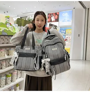 Detailed view of black and white striped casual backpack and tote bag with lace bow pendant.