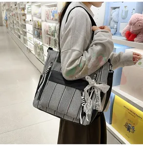 Detailed scene of a chic black and white striped tote bag with lace bow in a store.