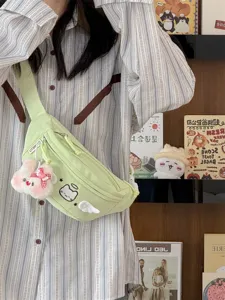 Cute green canvas chest bag featuring cat embroidery and plush rabbit pendant detail.
