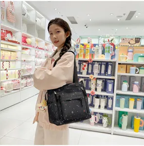 Stylish black canvas shoulder bag with colorful abstract prints, ideal for daily casual use.