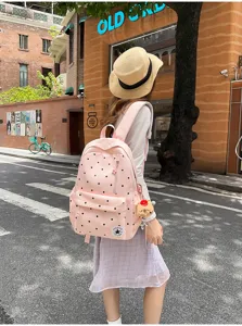 Vista dettagliata del grazioso zaino rosa a pois con portachiavi in peluche per uso quotidiano.