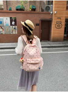 Vista dettagliata del grazioso zaino rosa a pois, tessuto morbido e borsa elegante da giorno.