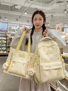 Cute doodle print school backpack and tote bag set with plush pendant for daily use.
