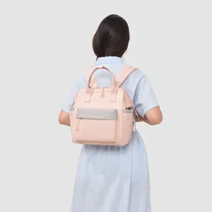 Vue détaillée du sac à dos maman rose à multiples compartiments et rangement pratique.