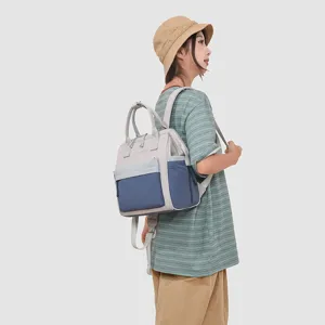 Vue détaillée du sac à dos maman à compartiments, gris et bleu, rangement pratique.