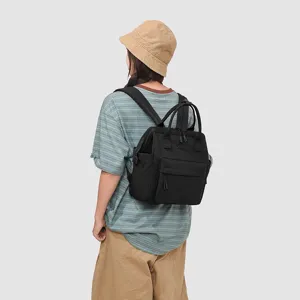 Vue détaillée du sac à dos à langer noir léger avec multiples compartiments et grande ouverture.