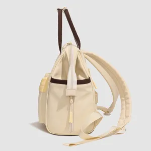 Détail du sac à dos à langer multi-compartiments avec poches de rangement, zips et bretelles.