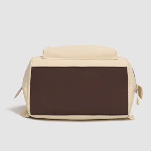 Gros plan sur le panneau inférieur contrasté, la fermeture éclair et le tissu résistant du sac.