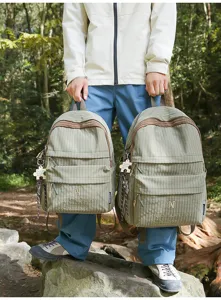 Detail view of the green plaid school backpack with front pocket and custom logo design.