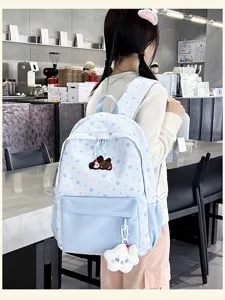 Niedlicher blauer Pünktchen-Schulrucksack für Mädchen mit süßem Welpen-Anhänger und Fächern.