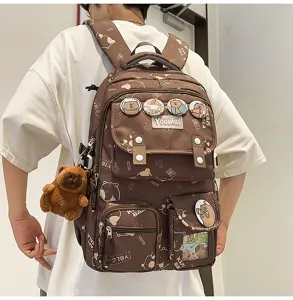 Dettaglio zaino capybara carino, borsa marrone con spille kawaii e ciondolo in peluche.