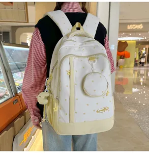 Vista dettagliata dello zaino in tela bianca carino con stelle gialle e tasche accessorie.