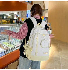 Vista dettagliata dello zaino bianco casual con stelle, borsa da studente leggera con piccola tasca.