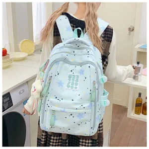 Light blue star print school backpack detail view, featuring cute pendant and pockets.