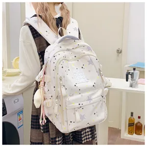 Detailed view of white canvas school backpack with stylish star pattern and spacious design.