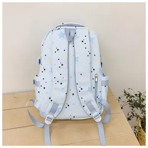 Detailed view of the light blue star-printed student backpack, showing back straps and design.