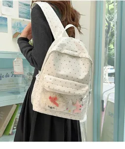Vue détaillée du joli sac à dos blanc à pois avec poche transparente et peluches à l'intérieur.