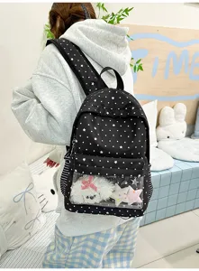 Détail de la poche avant transparente du sac à dos noir à pois avec de jolies peluches.