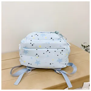 Close-up detail of the light blue star print backpack, showcasing pattern texture and design.