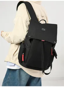 Detail view of a black canvas casual backpack featuring flap and drawstring closure.