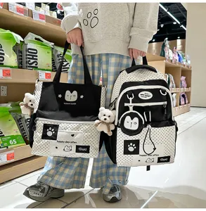 Detailed view of black and white polka dot student backpack and tote bag set with cute cat.