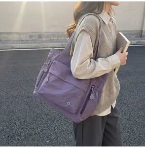 Detail view of the large purple nylon tote bag with multiple pockets for daily use.
