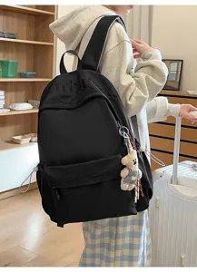 Casual black canvas backpack for daily commute and travel with cute bear pendant and spacious design.