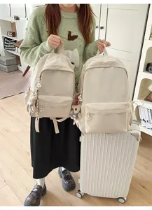 Casual solid color canvas backpack with cute bear pendant for daily commute and school use.