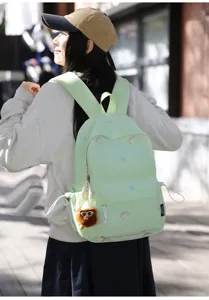 Cute embroidered light green school backpack detail with fluffy plush pendant for daily use.