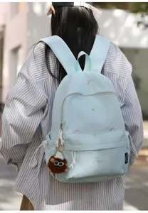 Detailed view of the cute Japanese embroidered light blue backpack with plush keychain charm.