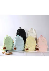 Cute Japanese style embroidered backpack with plush pendant for school or daily travel.