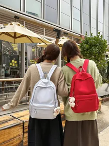 Detailed outdoor view of minimalist Japanese large capacity backpack with cute bear pendant.