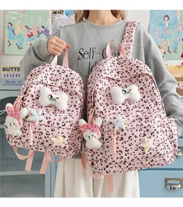 Pink leopard print school backpack with cute plush bunny and star charms for girls daily use.