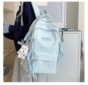 Sac à dos étudiant esthétique bleu clair vue détaillée avec broderie de nœuds pendentif peluche