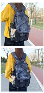 Outdoor street style backpack detail view featuring abstract print fabric and plush bear pendant.
