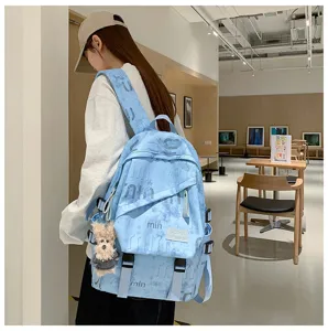 Backpack detail view showcasing street style design, light blue fabric, and pendant.