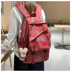 Stylish red canvas backpack for women, trendy college bookbag with cute bear pendant.