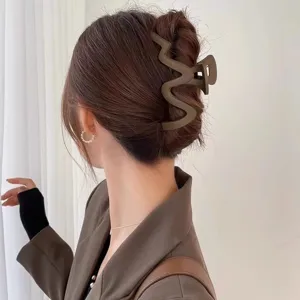Close-up detail of a large matte brown wavy hair claw clip showcasing its stylish grip design.