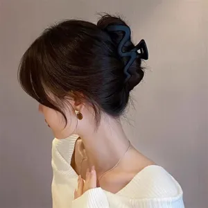 Large matte black wavy hair claw clip for women, stylish geometric shark hair styling accessory.