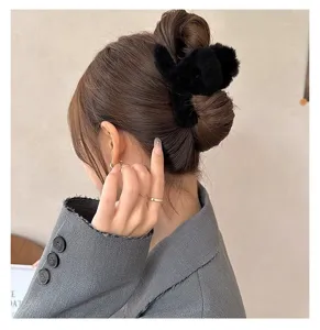 Detail view of a black plush hair claw clip, soft fluffy texture for daily styling.