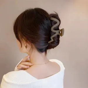 Large matte wave hair claw clip for women, elegant back head hair accessories styling detail.