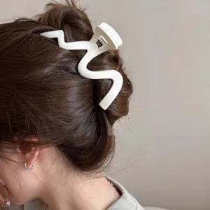 Detailed view of large matte wavy hair claw clip worn by model, elegant hair styling accessory.