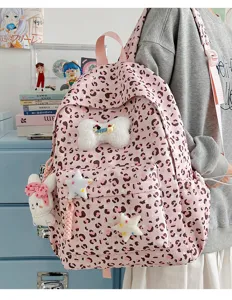 Detail view of a cute pink leopard print backpack featuring plush charms, ideal for daily use.
