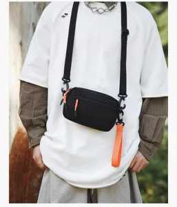 Casual black crossbody bag with vibrant orange zipper pulls, lightweight daily commuter sling bag.