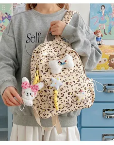 Detail shot of cute leopard print backpack with fluffy bunny charm and bow decoration.
