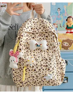Cute leopard print student backpack featuring adorable plush bunny and star decorative charms.