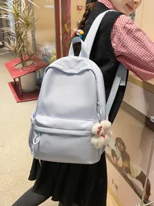 Casual light blue backpack for women, large capacity daily school bag with cute pendant detail.